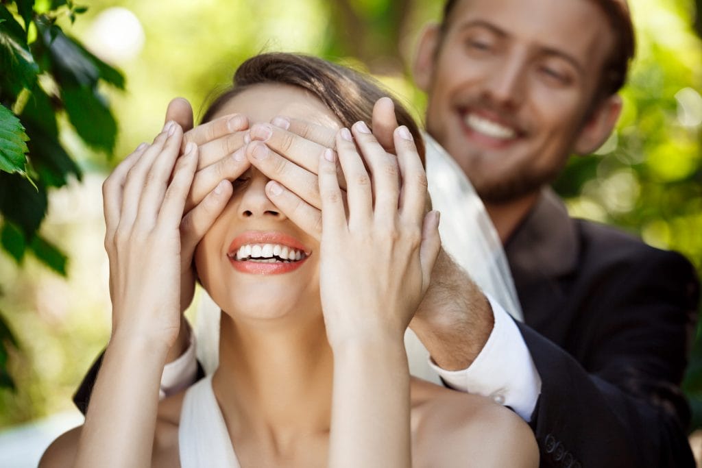 couple newlyweds smiling groom covering bride s eyes with hands